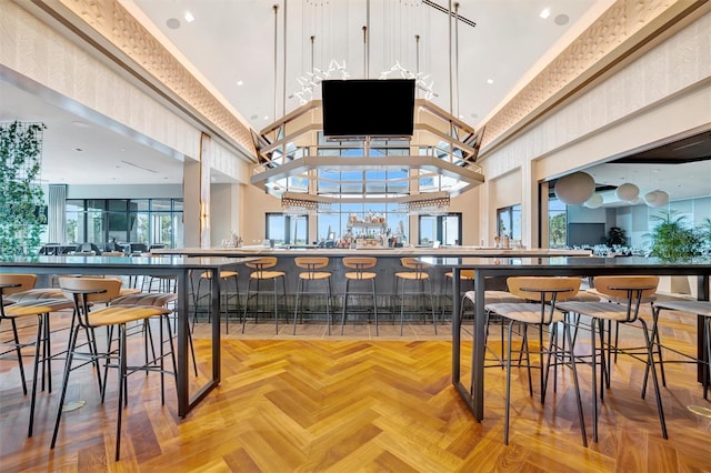 bar featuring parquet floors and a high ceiling