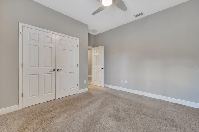 unfurnished bedroom with light carpet, ceiling fan, and a closet