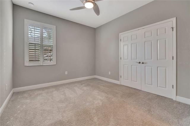 unfurnished bedroom featuring ceiling fan, a closet, and light carpet