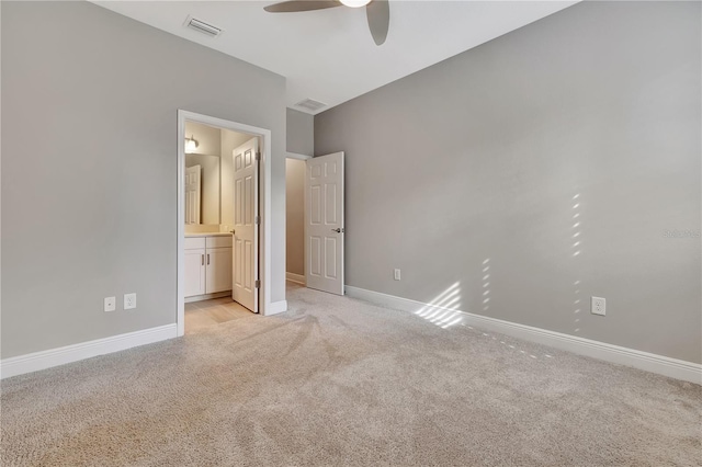 unfurnished bedroom with ceiling fan, light colored carpet, and ensuite bath