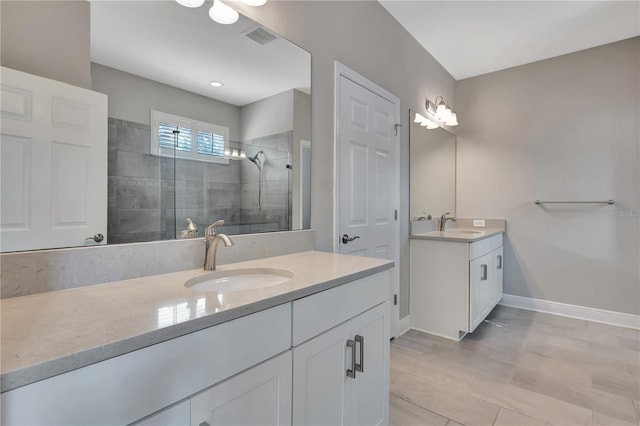 bathroom featuring walk in shower, vanity, and tile patterned flooring