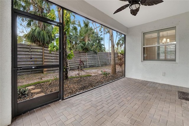 unfurnished sunroom with ceiling fan