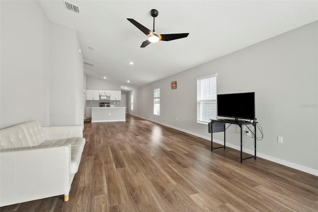 living room with dark hardwood / wood-style flooring, vaulted ceiling, and ceiling fan