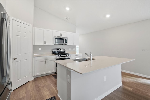 kitchen featuring sink, stainless steel appliances, an island with sink, light hardwood / wood-style floors, and white cabinets