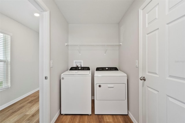 laundry room featuring separate washer and dryer and light hardwood / wood-style floors