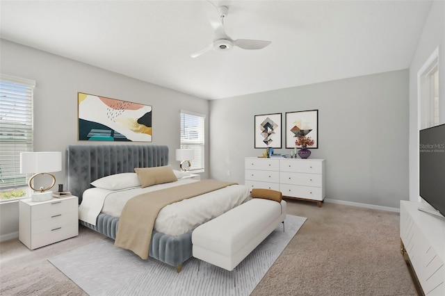 bedroom with multiple windows, ceiling fan, and light colored carpet