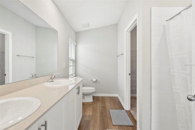 bathroom featuring curtained shower, vanity, wood-type flooring, and toilet