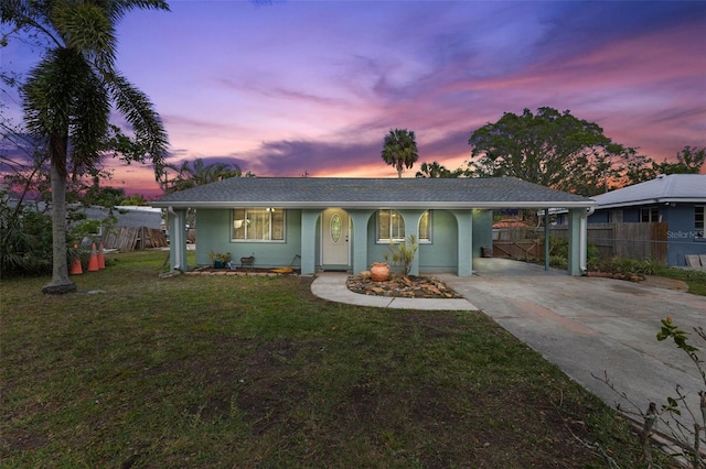 single story home featuring a carport and a yard