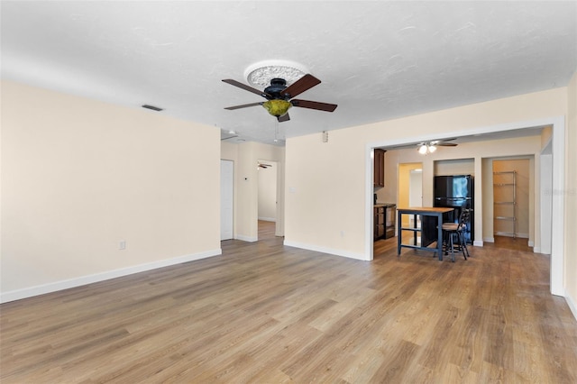 unfurnished living room with ceiling fan and light hardwood / wood-style floors