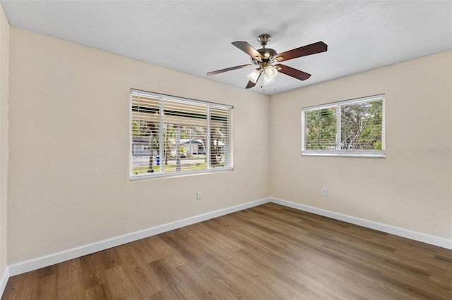 empty room with ceiling fan and hardwood / wood-style flooring