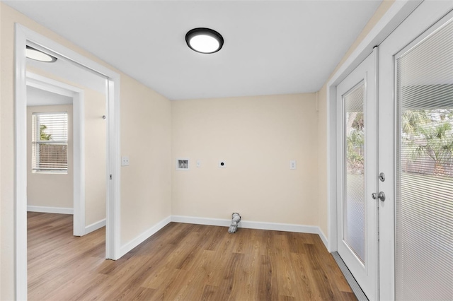 clothes washing area featuring hookup for an electric dryer, hookup for a washing machine, and light hardwood / wood-style flooring