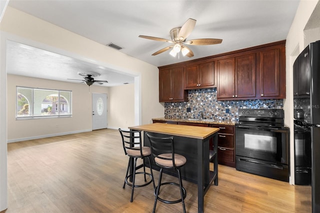 kitchen featuring wooden counters, black appliances, sink, light hardwood / wood-style flooring, and ceiling fan