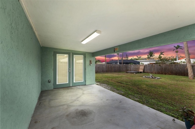 patio terrace at dusk with french doors and a lawn