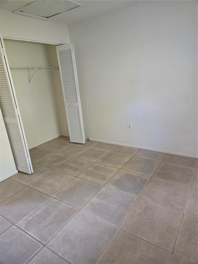 unfurnished bedroom featuring light tile patterned floors and a closet