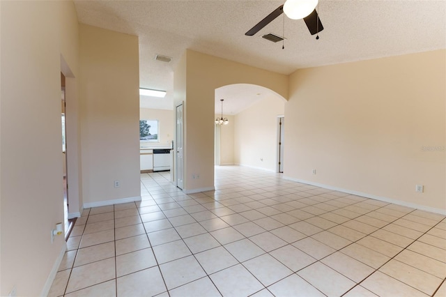 tiled spare room with a textured ceiling and ceiling fan with notable chandelier