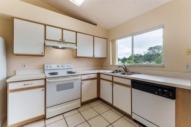 kitchen featuring white appliances, vaulted ceiling, sink, light tile patterned floors, and white cabinetry