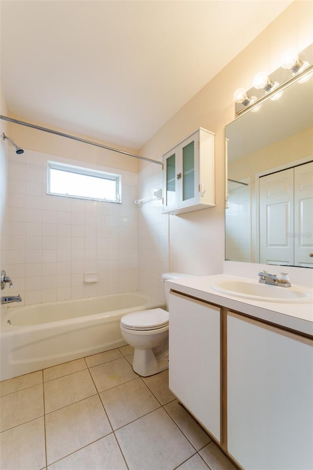 full bathroom featuring tile patterned flooring, tiled shower / bath combo, toilet, and vanity