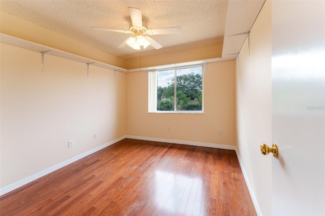 unfurnished room featuring ceiling fan, hardwood / wood-style floors, and a textured ceiling