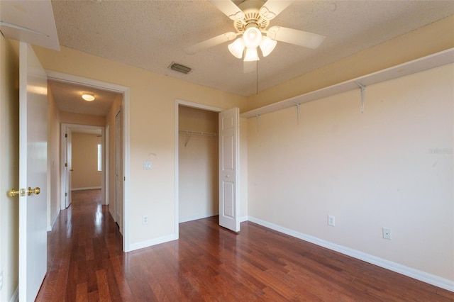 unfurnished bedroom featuring ceiling fan, dark hardwood / wood-style floors, a textured ceiling, and a closet