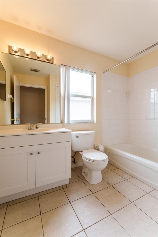 full bathroom featuring tile patterned floors, vanity, tiled shower / bath, and toilet