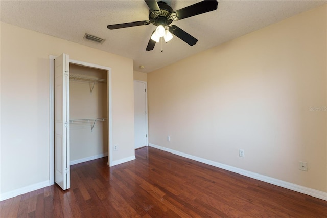 unfurnished bedroom featuring a textured ceiling, a closet, ceiling fan, and dark hardwood / wood-style floors