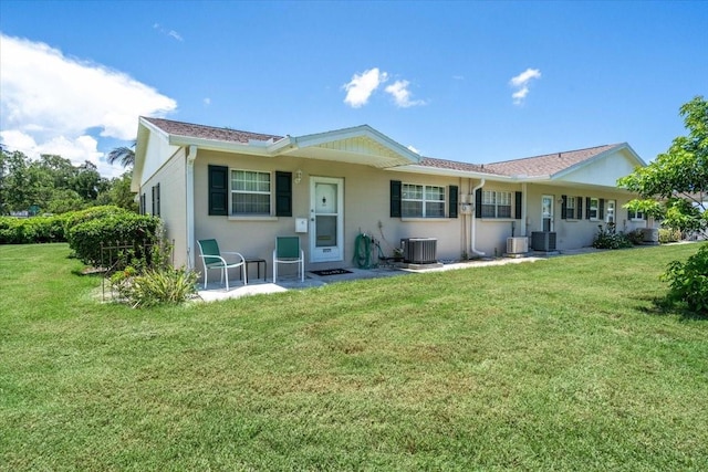 rear view of property with cooling unit and a yard