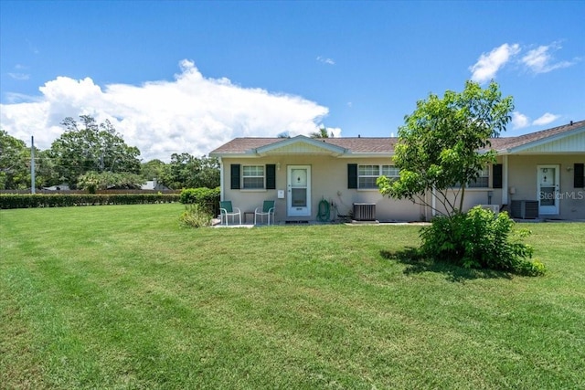 back of property featuring central AC and a yard