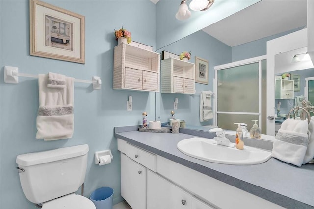 bathroom with vanity, toilet, and an enclosed shower