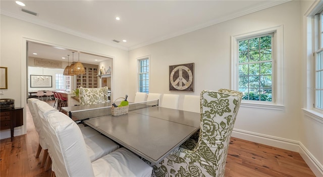 dining room featuring ornamental molding and light wood-type flooring