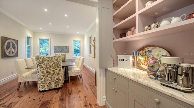 dining area with crown molding and light hardwood / wood-style flooring