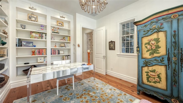 interior space featuring an inviting chandelier, hardwood / wood-style flooring, and built in shelves