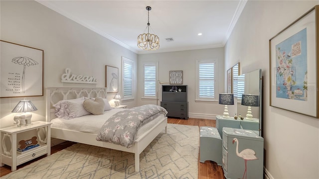 bedroom featuring a notable chandelier, wood-type flooring, and ornamental molding