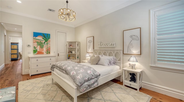 bedroom with a notable chandelier, ornamental molding, and light wood-type flooring