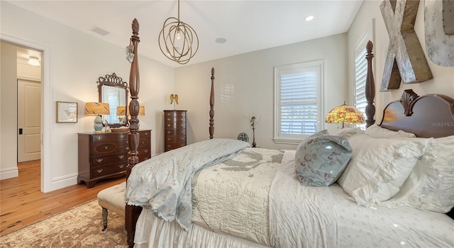 bedroom with an inviting chandelier and wood-type flooring