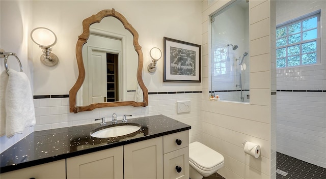 bathroom with a tile shower, vanity, tasteful backsplash, and toilet