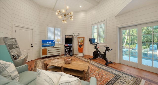 living room with wood-type flooring, a wealth of natural light, and wooden walls