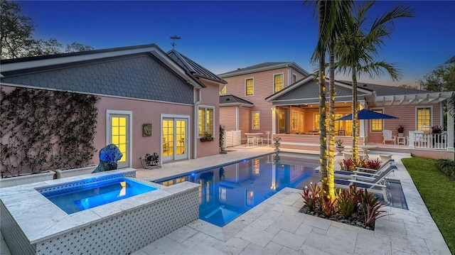 pool at dusk with an in ground hot tub, a pergola, a patio, and french doors