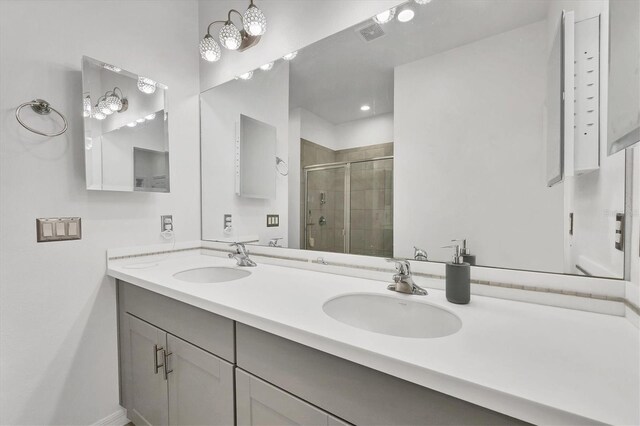 bathroom featuring a shower with door and vanity