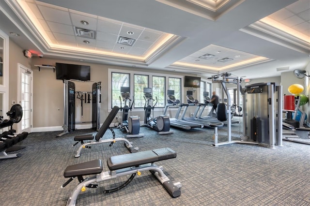 exercise room featuring carpet, a paneled ceiling, and a raised ceiling