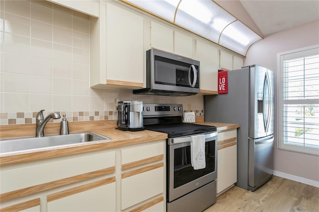 kitchen featuring sink, a wealth of natural light, appliances with stainless steel finishes, and decorative backsplash