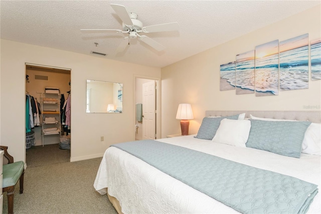 carpeted bedroom featuring a closet, ceiling fan, a spacious closet, and a textured ceiling