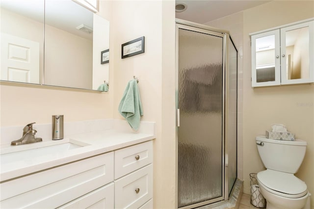 bathroom with vanity, toilet, and a shower with door