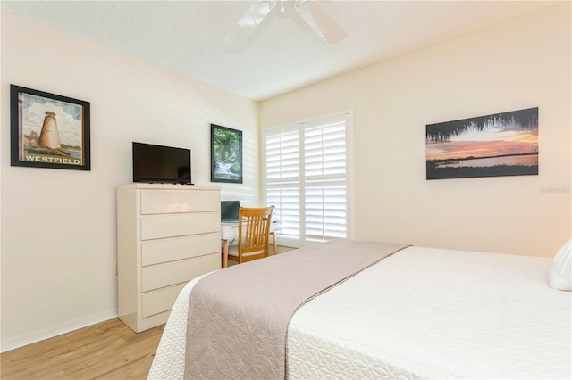 bedroom with ceiling fan, a textured ceiling, and light wood-type flooring