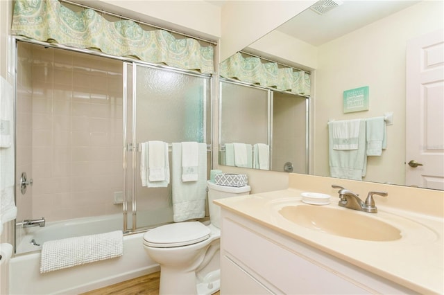 full bathroom with vanity, toilet, combined bath / shower with glass door, and hardwood / wood-style flooring