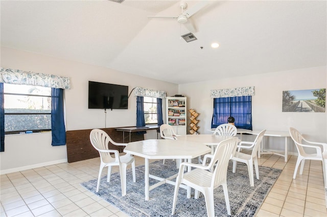 dining room featuring ceiling fan, light tile patterned floors, and lofted ceiling