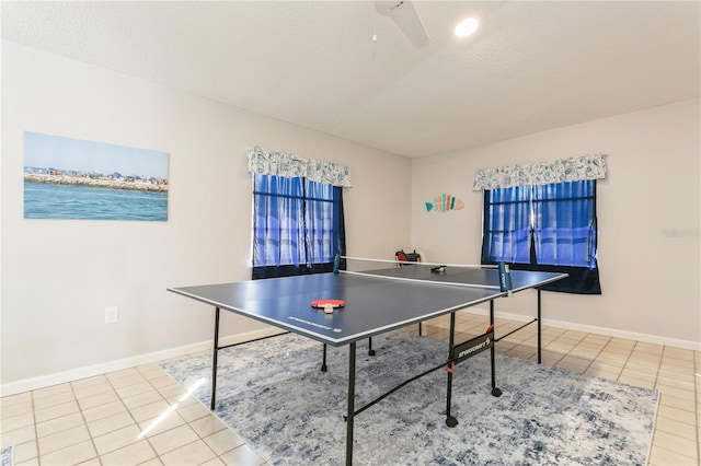 rec room featuring light tile patterned flooring, a textured ceiling, and ceiling fan