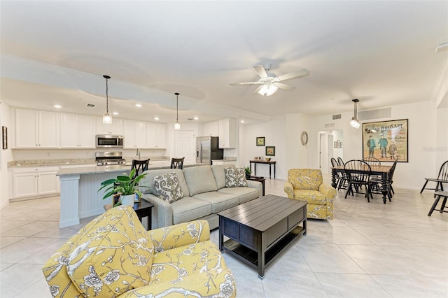 tiled living room featuring ceiling fan and ornamental molding