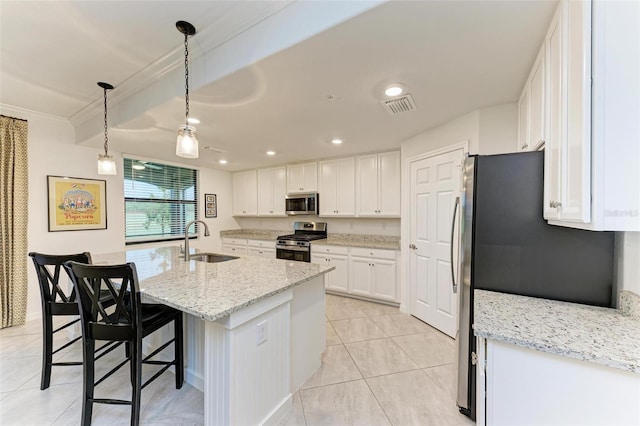 kitchen featuring pendant lighting, a kitchen island with sink, white cabinets, sink, and appliances with stainless steel finishes