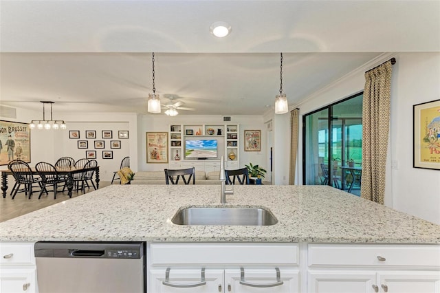 kitchen with sink, white cabinets, stainless steel dishwasher, and decorative light fixtures