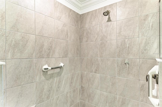 bathroom featuring a tile shower and ornamental molding